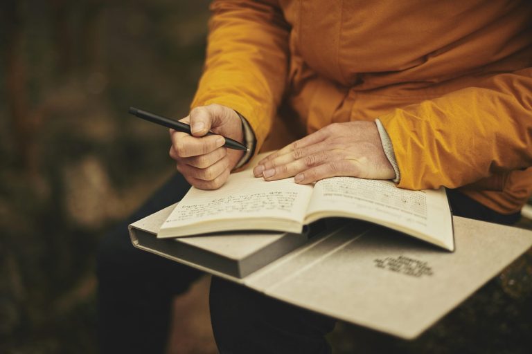 O seară de călătorit prin România fără să ieși din sufragerie Femeie pe canapea, cu o hartă veche și o cană de ceai în mână, într-o seară liniștită