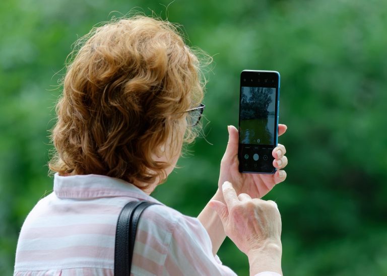Persoană care verifică setările telefonului în sufrageria unei case